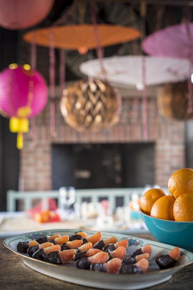 Orange sections dipped in chocolate with Chinese lanterns and paper umbrellas in the background
