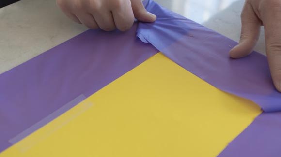 Wrapping purple paper over cardboard