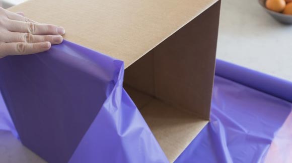 Wrapping a box with purple paper