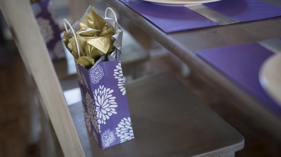 Purple gift bag with silver and gold tissue paper